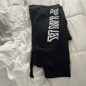 Comfy black with white writing Pink sweat pants cuffed at the bottom.